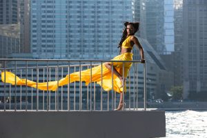 Stunning fashion model in flowing yellow dress with Chicago skyline backdrop. — Horizon Work out Bikes Evaluation